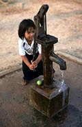 Schoolmeisje gebruikt waterpomp, Cambodja